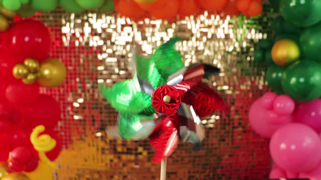 tradicional giratorio mexicano con decoración de globos y telón de fondo dorado