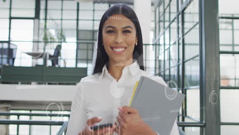 animación de gráficos, barras de carga, círculos sobre una mujer biracial sonriente sosteniendo archivos y teléfono móvil