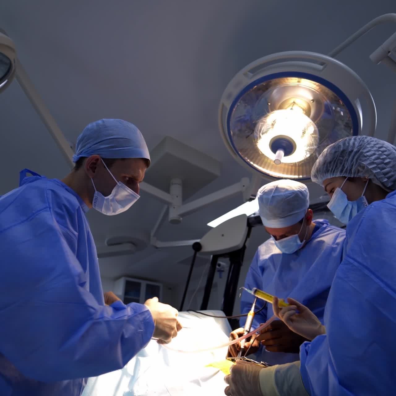 Operazione neurochirurgica in corso. Professionisti che utilizzano strumenti innovativi in primo piano. Vista dal basso