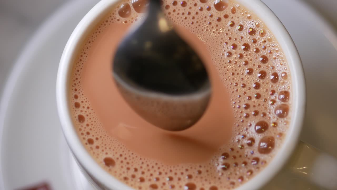 Una tazza di tè al latte con un cucchiaino