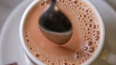 a cup of milk tea with a spoon