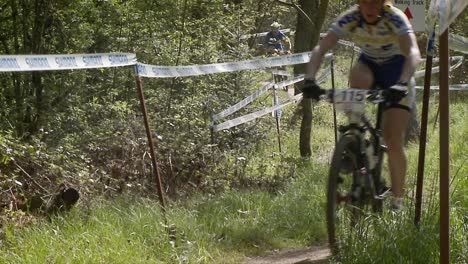 a group of mountain bikers race up a courses trail