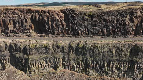 Drone-shot-of-a-highway-in-Easter-Washington-along-a-cliff-side