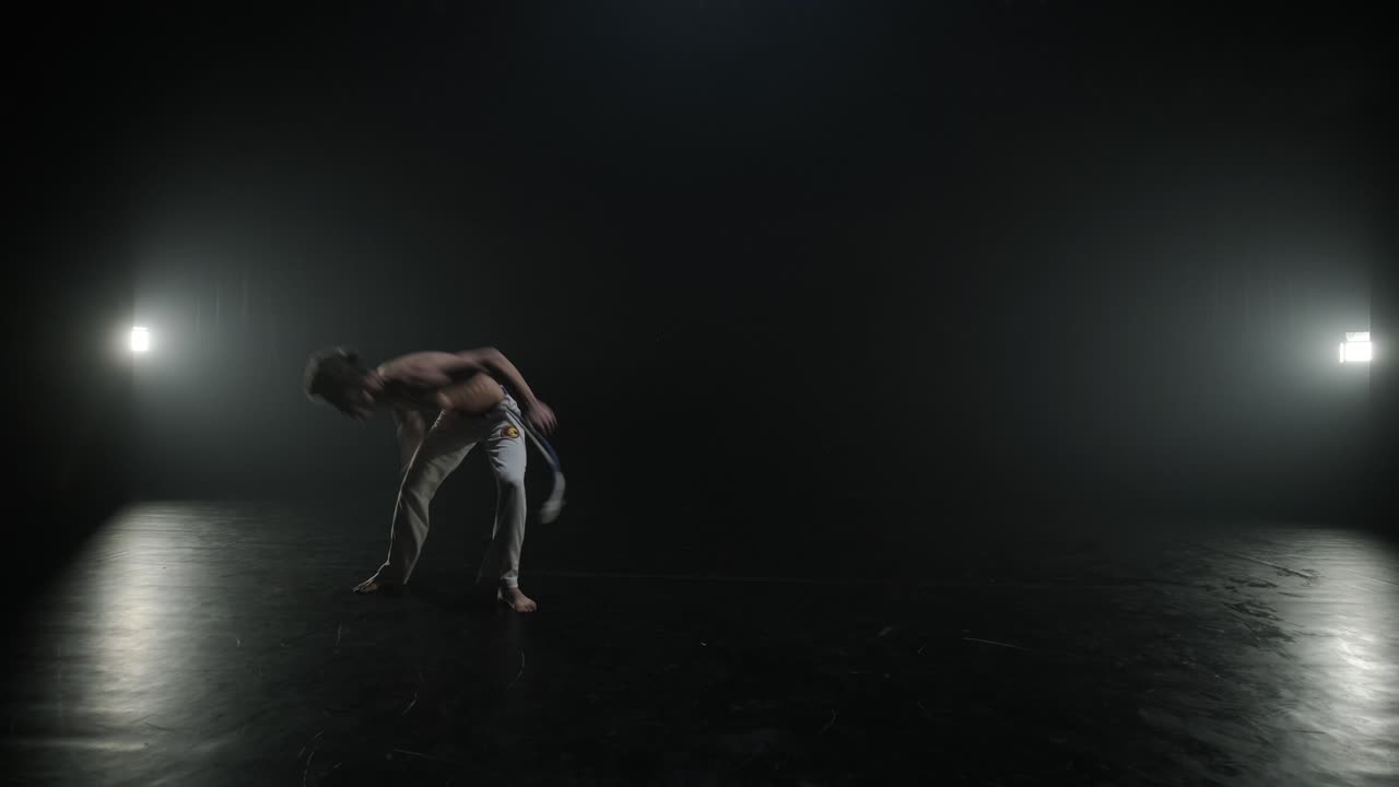 무대에서 역동적인 움직임을 보이는 카포에라 싸움, 무술, 춤, 액션 아크로바틱스, 스포트라이트 아래에서 힘, 유연성 및 기법을 보여주는 벌거벗은 가 운동선수