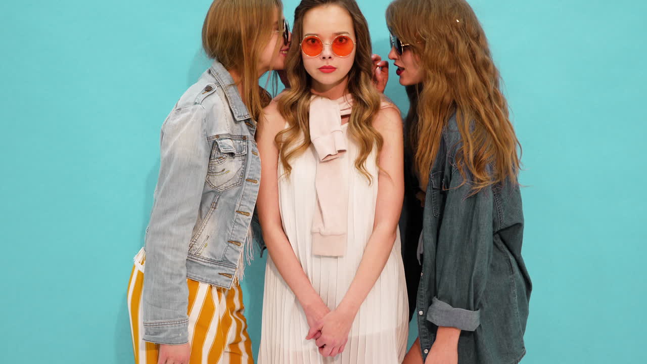 세 명의 십대 소녀들이 패션 의상을 입고 포즈를 취하고 있습니다.