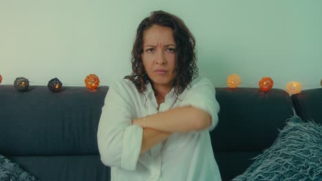 woman appearing upset or unhappy sitting on a couch