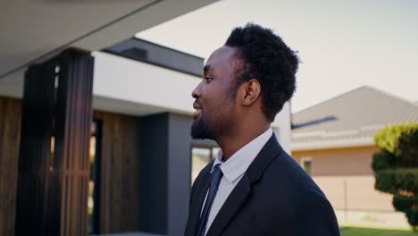 business man in front of modern home