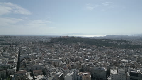 a drone flies towards the pantheon over athens, showcasing the dense cityscape and the iconic pantheon above