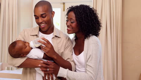 Happy-father-feeding-baby-son-with-mother