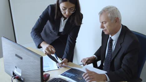 focused female project manager explaining document details to broker