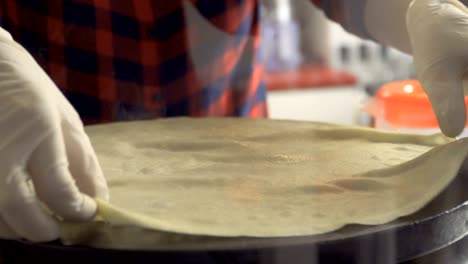 el chef da la vuelta a la panqueque durante su preparación