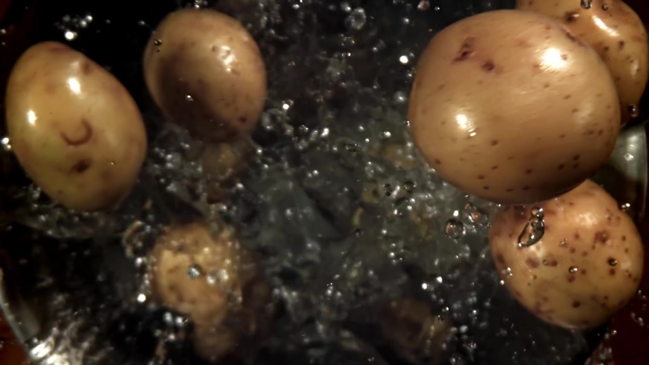 Ripresa al rallentatore di patate che schizzano nell'acqua
