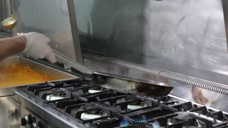 chef cooking and flambéing vegetables in a frying pan, 4k footage-1