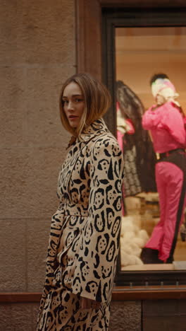 woman in leopard print coat walking in front of a store