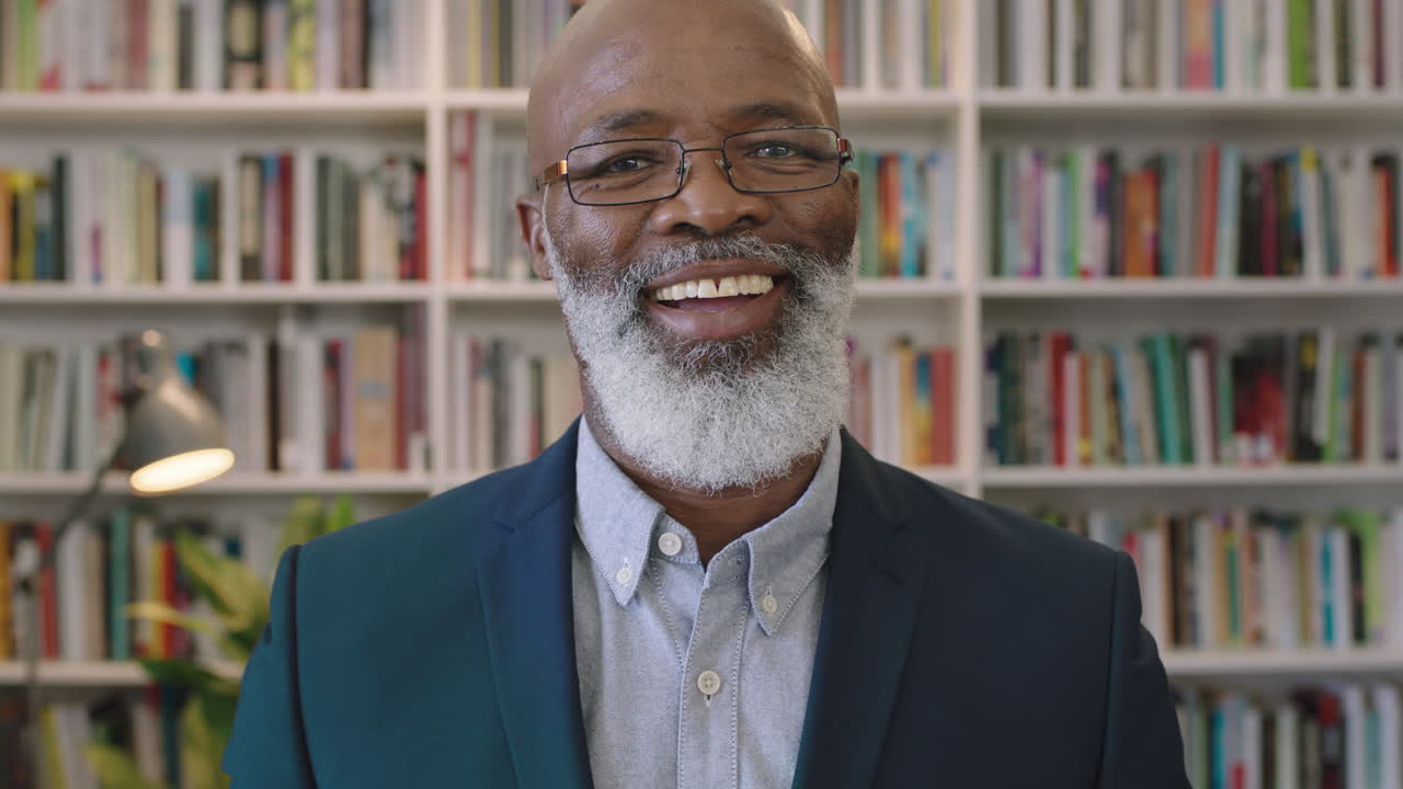 ritratto di un uomo d'affari afroamericano maturo che ride allegro godendo di una carriera di successo pietra miliare professionista maschio nero che indossa occhiali nello studio della biblioteca