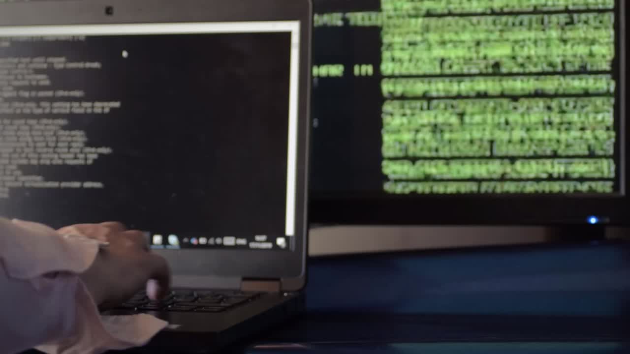 Network engineer typing on computer with green code background