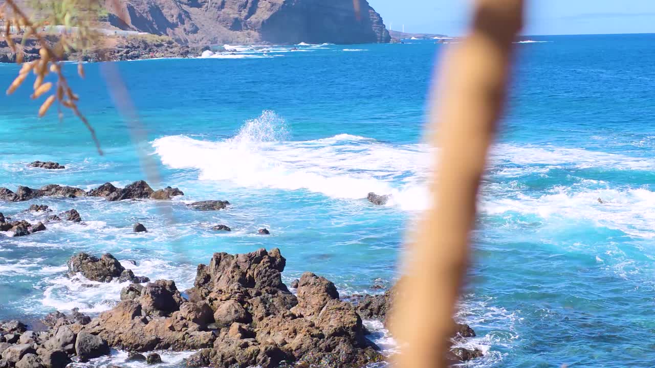 Blue ocean waves crash on rocky Canary Islands coast
