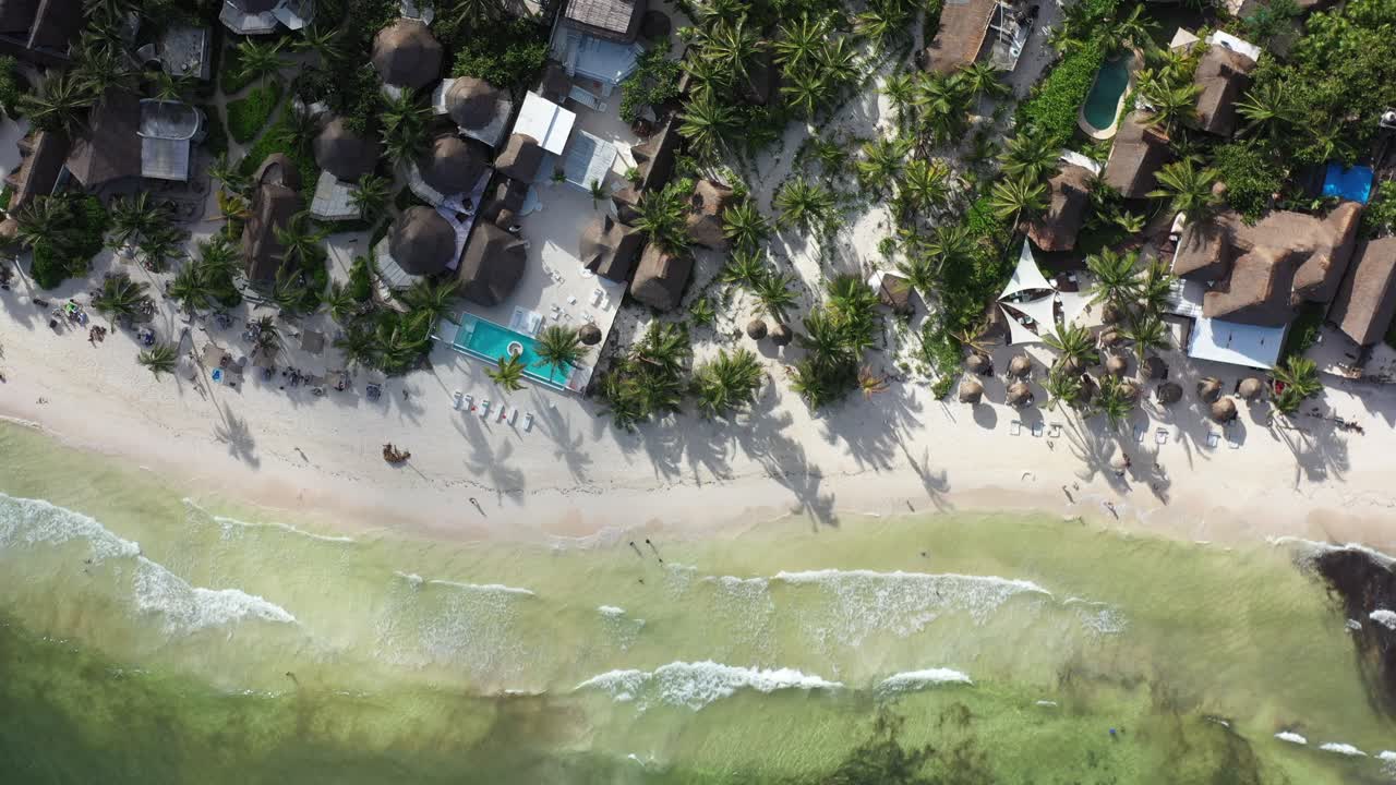 toma aérea de drones cenital de playa tropical con exclusivo complejo turístico.