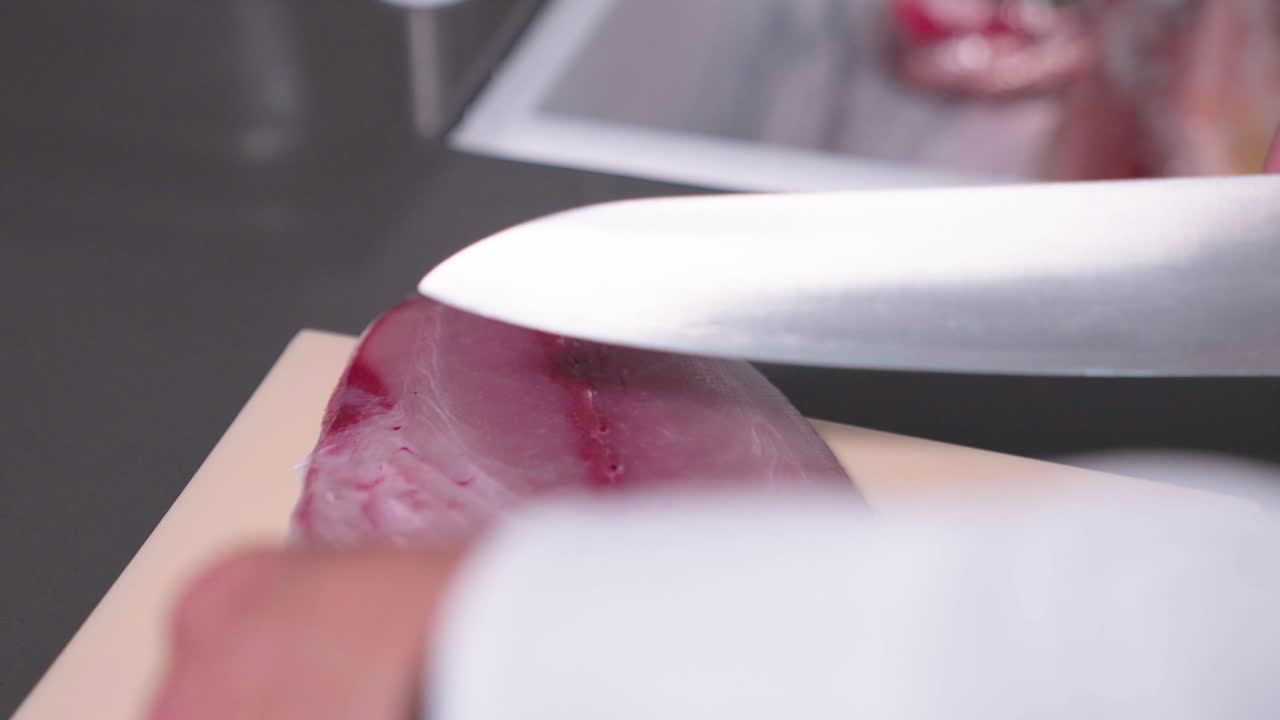 A static shot captures a sushi chef cutting parts of fish for disposal, showcasing the precision and efficiency in food preparation. Ideal for culinary, sushi, and kitchen waste content.