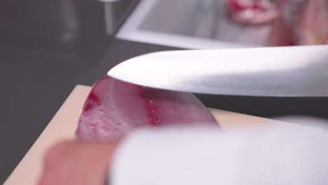 a static shot captures a sushi chef cutting parts of fish for disposal, showcasing the precision and efficiency in food preparation. ideal for culinary, sushi, and kitchen waste content.