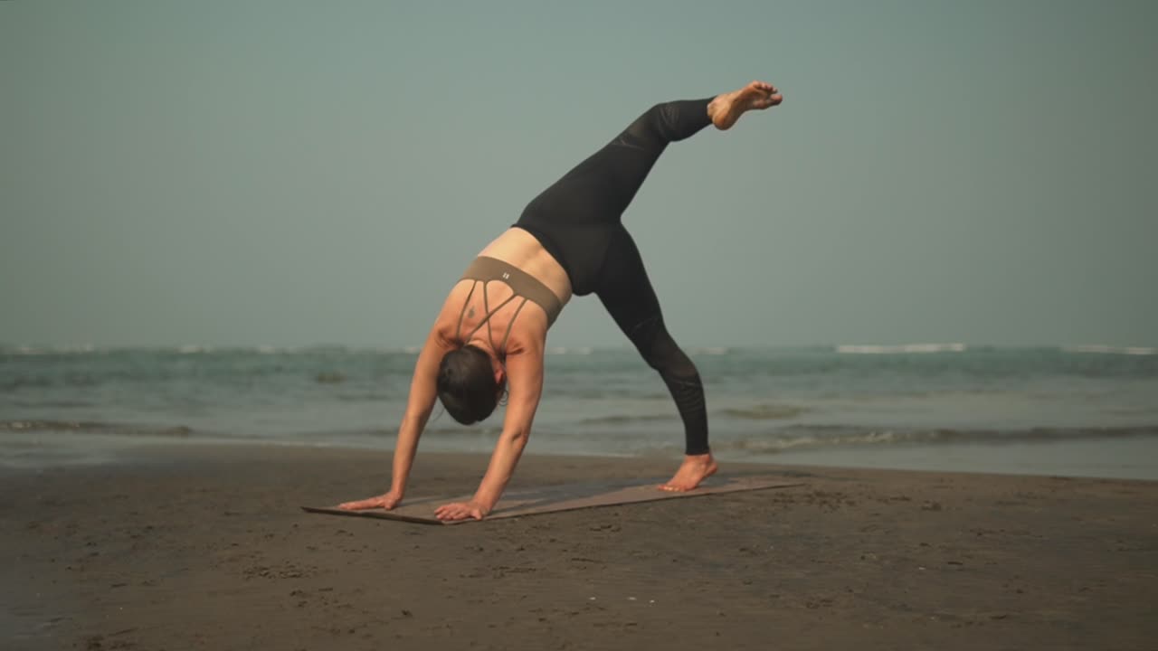 hermosa mujer deportiva haciendo una sesión de yoga en la playa