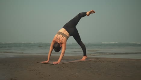 Hermosa-Mujer-Deportiva-Haciendo-Una-Sesión-De-Yoga-En-La-Playa