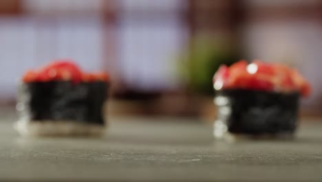 primer plano de un rollo de sushi con palillos