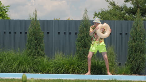 man playing with pool float in a garden