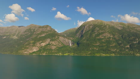 vista general aérea de la cascada en cascada a la distancia del fiordo de lustra, noruega, en verano