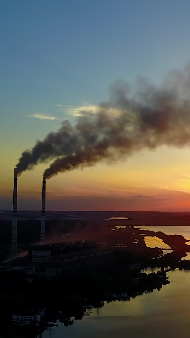 Industrial Building In Country Side. Pipe with smoke near people which spend time near river Vertical video