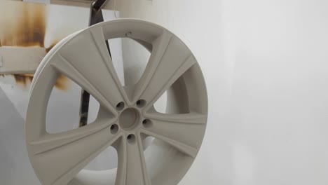 hanging the wheel with freshly applied primer powdercoat on the rack, in 4k.