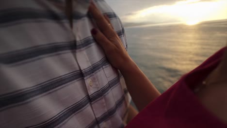 loving couple kissing on rocky cliff near sea