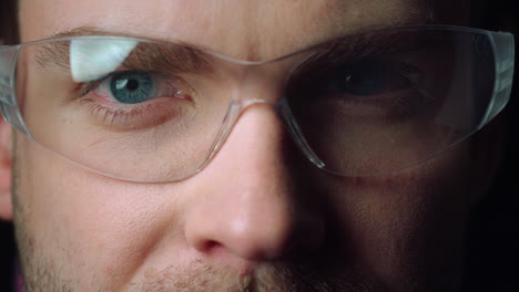 close up portrait of young man wearing glasses. focused blue eyes of male.