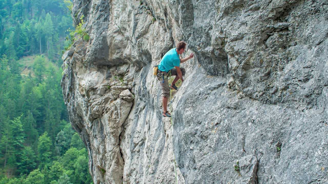 Man rock climbing up a mountain rocky vertical wall, area Burjakove peci, Alps