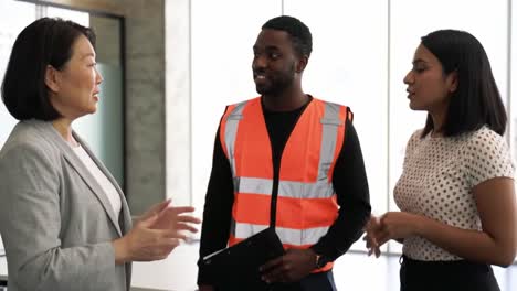 in a bright, contemporary office, three team members engage in a lively discussion about their project's developments and next steps while showcasing professional attire and teamwork.