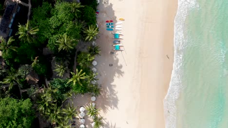 Fly-through-aerial-drone-shot-of-Pansea-Beach-located-in-Phuket-island,-showing-a-pristine-getaway-for-tourists-in-Thailand