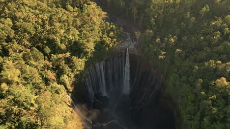 a tilt up panoramic view of the touristic tumpak sewu waterfall with its hundred stunning waterfalls - east java - indonesia