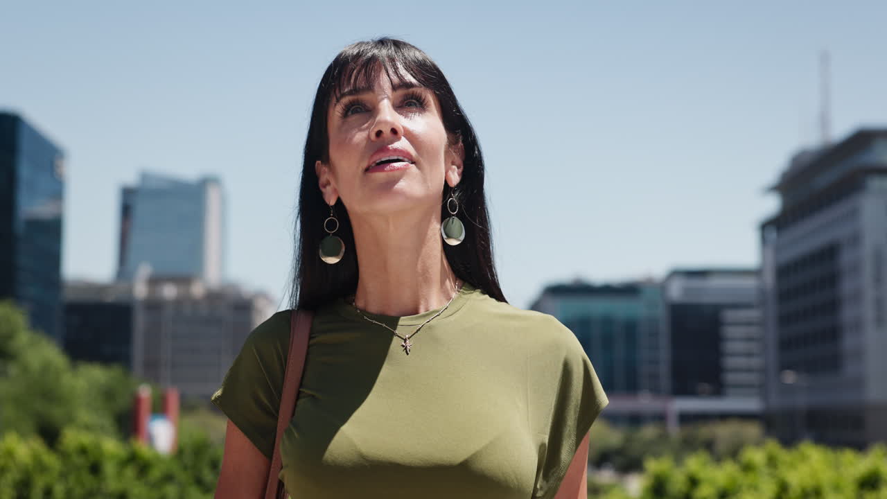 Mulher descontraída aproveitando a luz do sol ao ar livre na cidade.