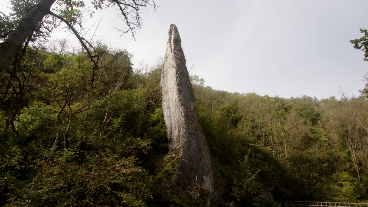 foto ancha de la roca de ilam con un fondo boscoso en dovedale