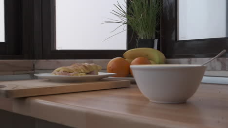 croissant with ham and a bowl of yogurt with fruits on the table for breakfast - dolly forward