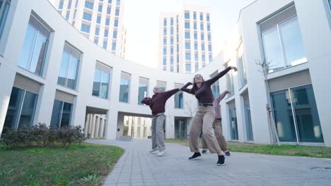 young women dancing modern choreography outdoors