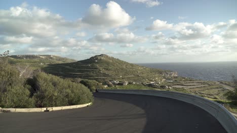 carretera asfaltada con curvas que conduce cerca de la costa de malta con una gran vegetación en plateu