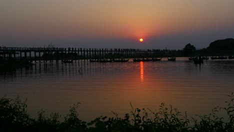 Silueta-De-La-Hermosa-Puesta-De-Sol-En-El-Histórico-Puente-De-Teca-U-Bein-En-Amarapura-Cerca-De-Mandalay,-Myanmar,-El-Puente-Peatonal-De-Madera-De-Teca-Más-Antiguo-Y-Largo-Del-Mundo