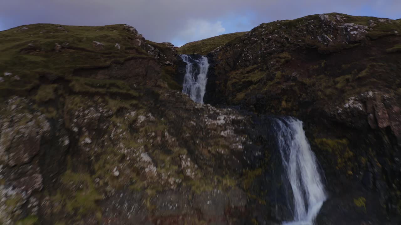 drone aéreo sobrevuelo de una cascada con vacas en fairy glen en skye escocia otoño