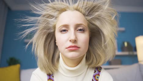 una mujer rubia desesperada y preocupada. su cabello está volando.