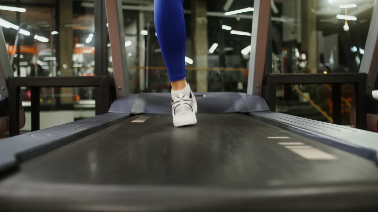 Woman Running on a Treadmill in a Gym