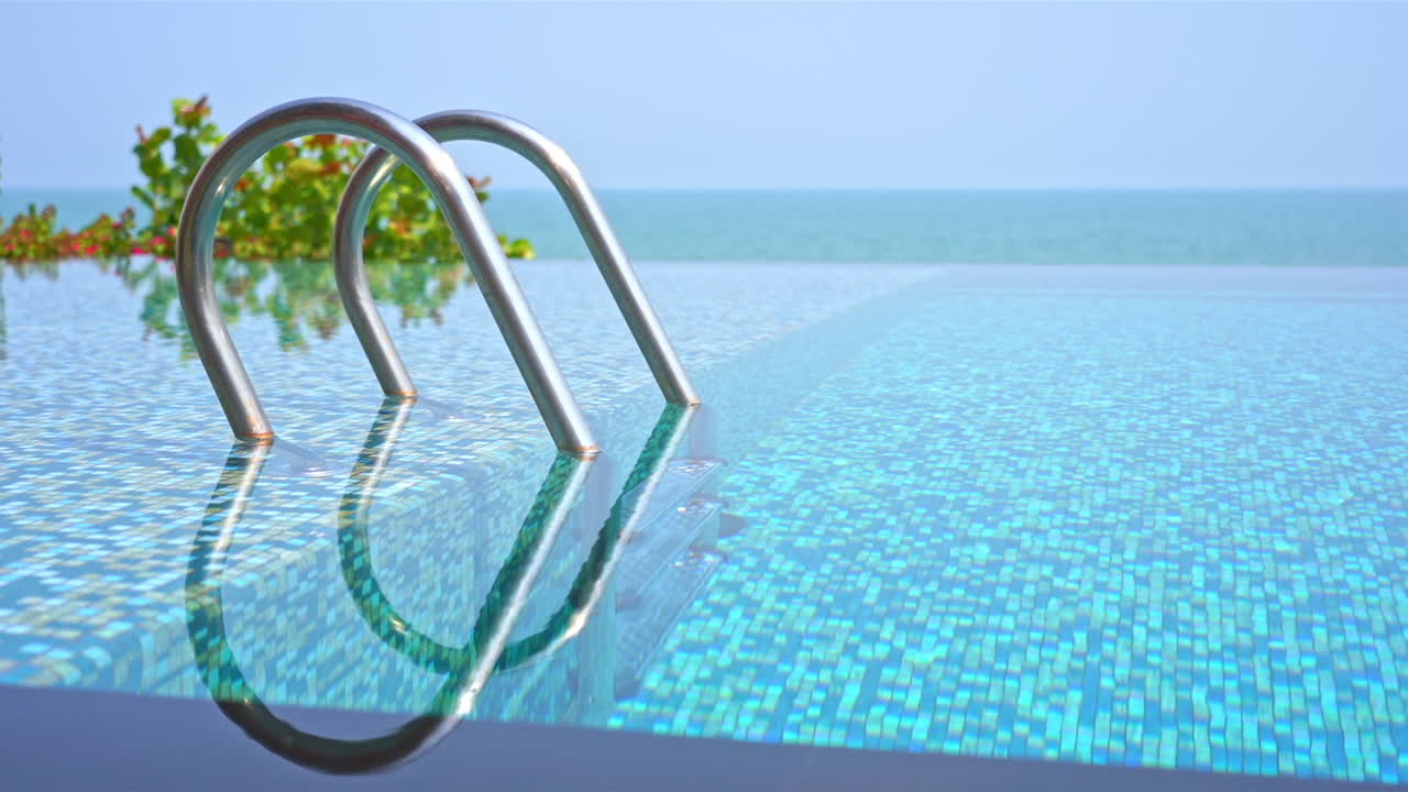 Nahaufnahme eines leeren Resort-Pools mit Ozean im Hintergrund