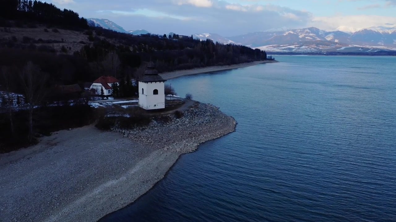 Forlatt gammel kirke nær innsjø om kvelden.