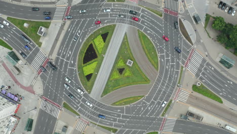 aerial drone top down view of the onz roundabout in the center of warsaw with passing cars at cloudy day