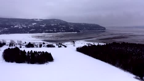 aerial shot turning around baie saint-paul in quebec in winter